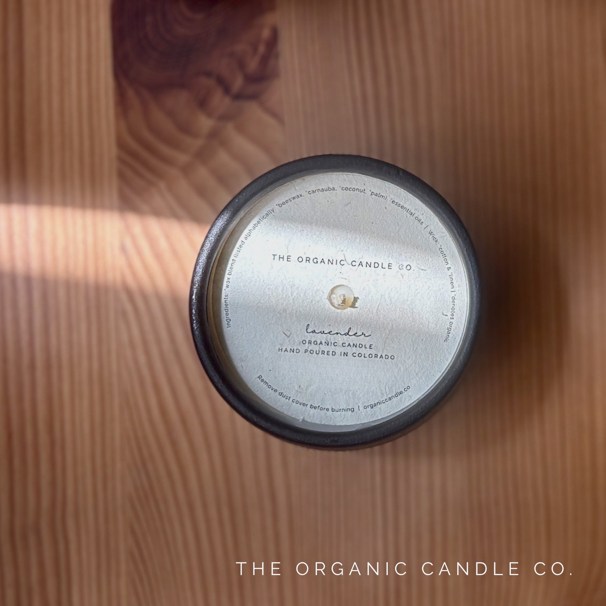 Organic candle with label on a wooden surface, featuring 'The Organic Candle Co.'