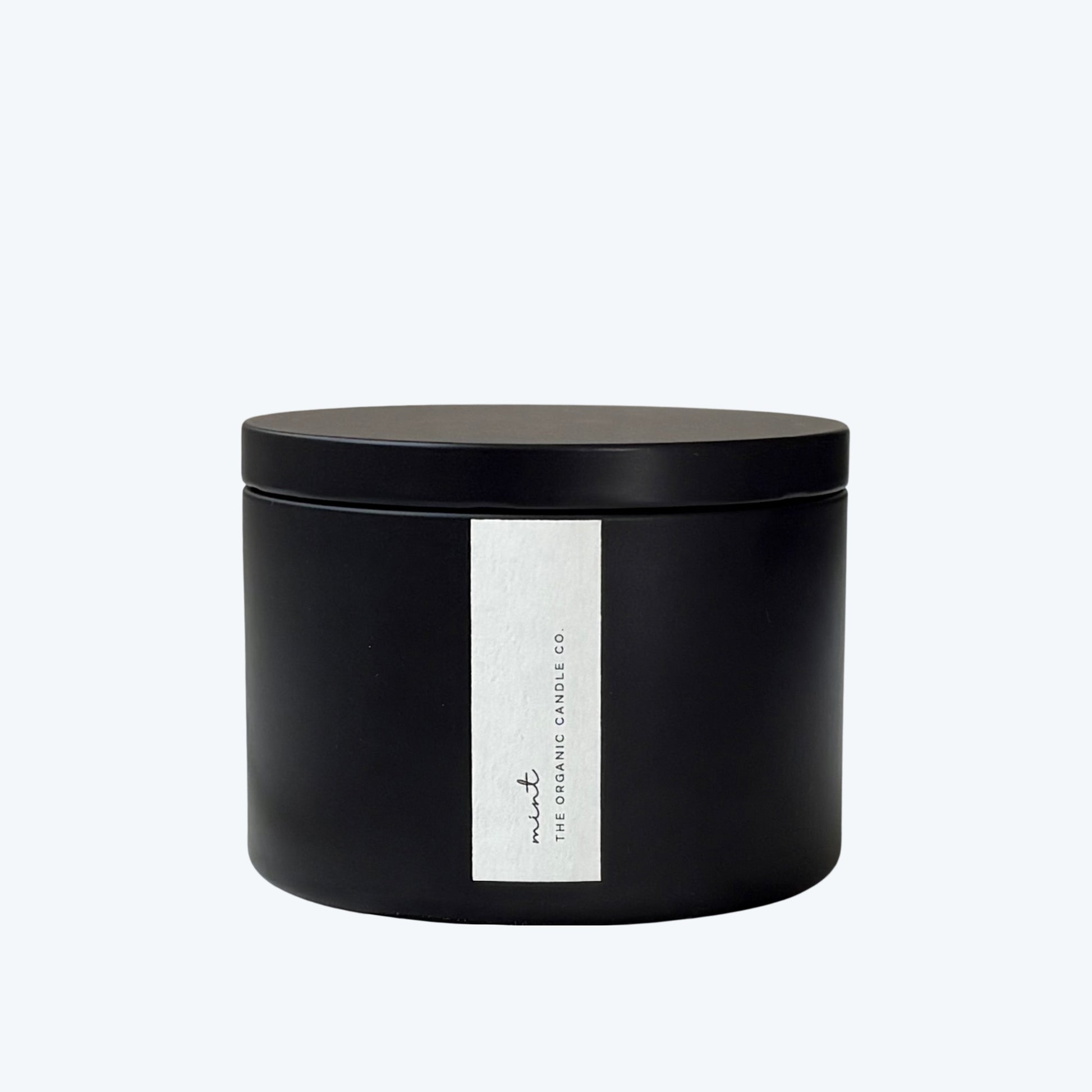 Black candle jar with a white label featuring 'The Organic Candle Co.' on a light gray background