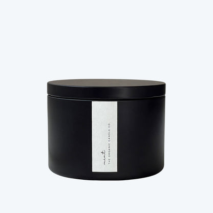 Black candle jar with a white label featuring 'The Organic Candle Co.' on a light gray background
