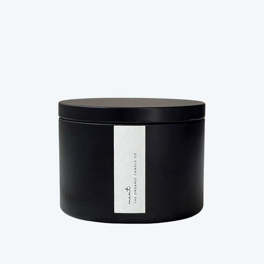 Black candle jar with a white label featuring 'The Organic Candle Co.' on a light gray background