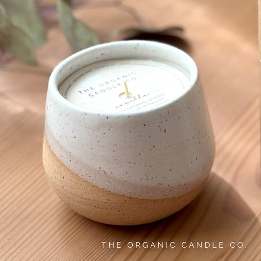 Organic candle in ceramic vessel on a neutral background
