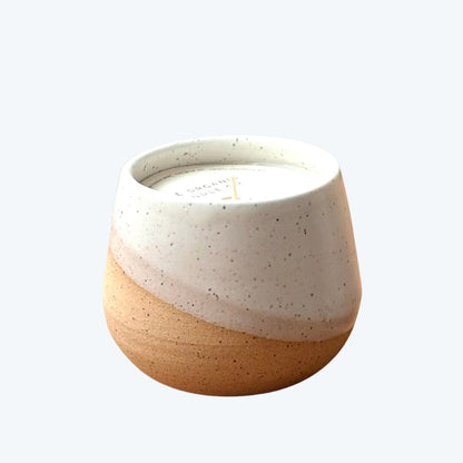 Organic candle in ceramic vessel on a neutral background