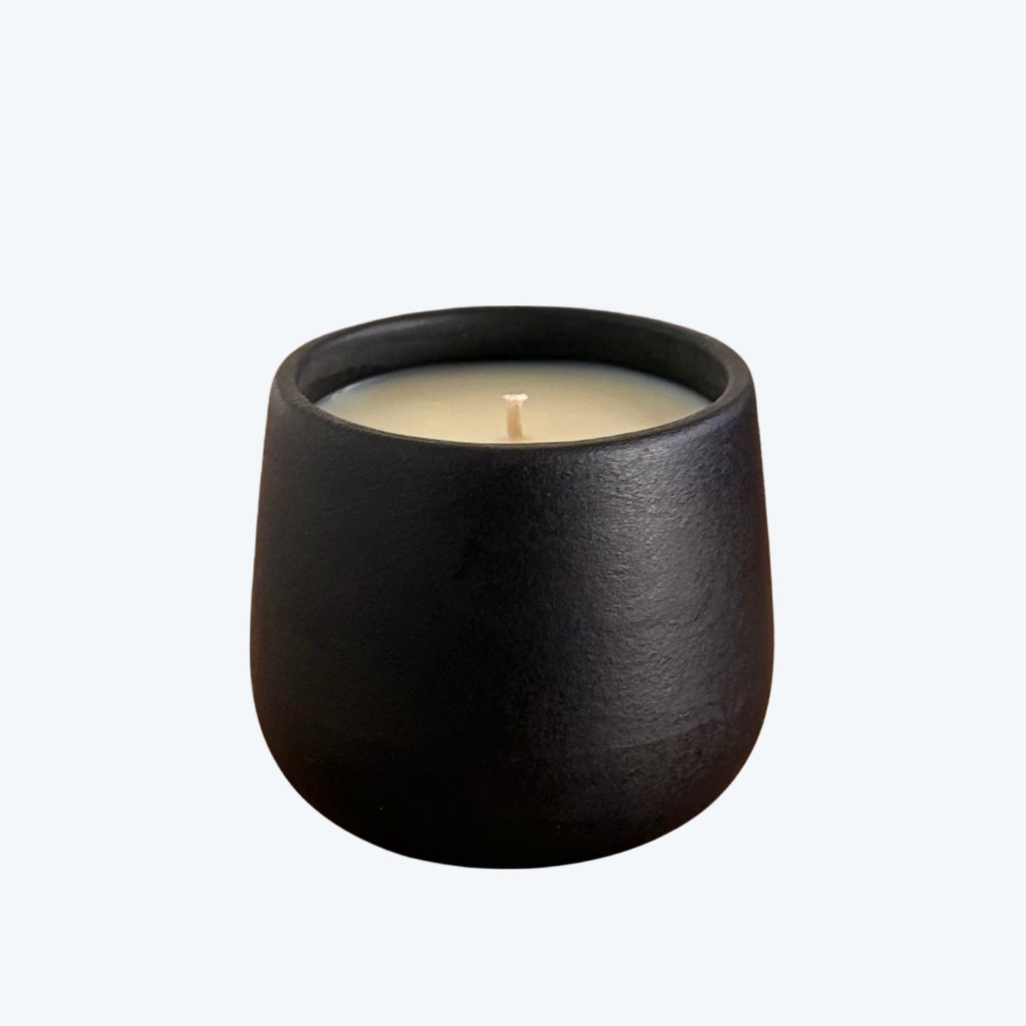 Black organic candle on a neutral background