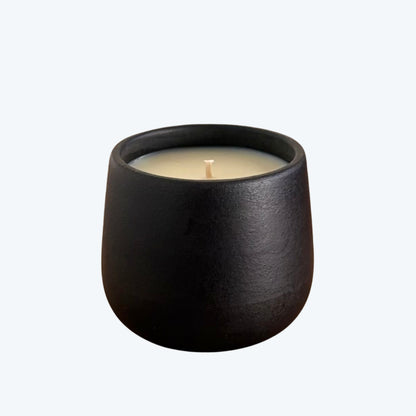 Black organic candle on a neutral background