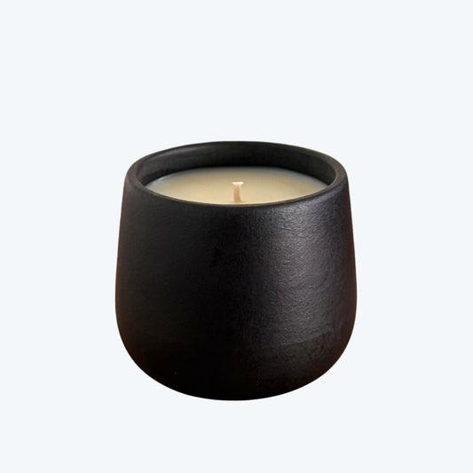 Black organic candle on a neutral background