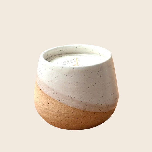 Organic candle in ceramic vessel on a neutral background