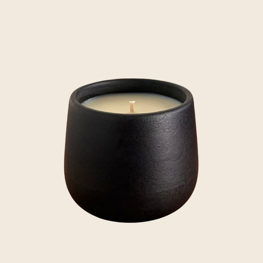 Black organic candle on a neutral background