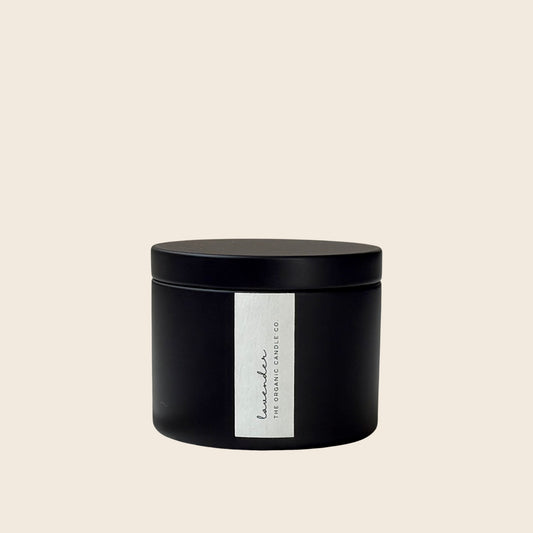 Organic candle in a black cylindrical container with a white label featuring 'The Organic Candle Co.' on a neutral background