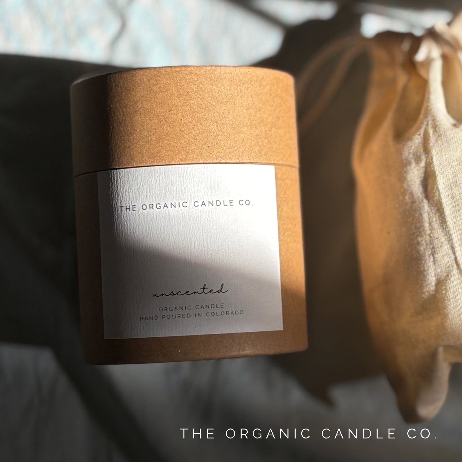 Candle packaging with 'The Organic Candle Co.' label on a blurred background